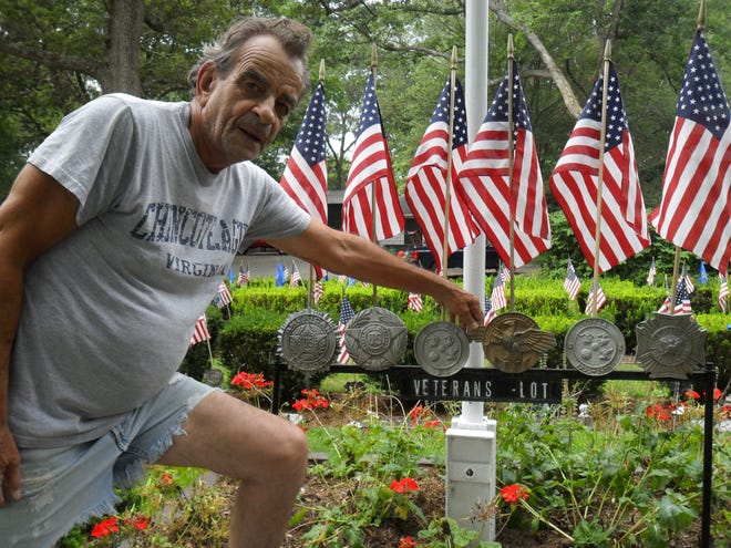 William Vegnani, chairman of the Abington Veterans Memorial Trust Committee, shows the various memorial medallions from past wars used to adorn veterans graves.