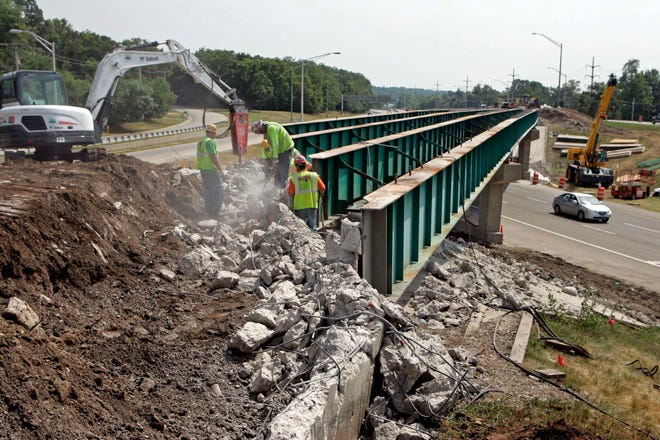 Workers remove concrete Monday, July 18, 2011, from the Forest Hills Road bridge over North Second Street in Rockford.