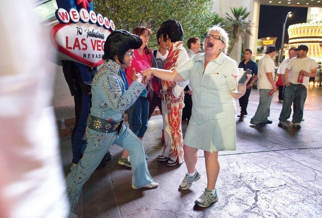 Elvis impersonator Tony Gallardo (left) dances with tourist
Leigh Moorhead of Hampton, Va., outside a casino along The Strip in
Las Vegas.