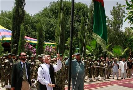 Ashraf Ghani, head of the Transition Commission raises Afghanistan's flag during the transfer of authority in Mehterlam, Laghman province, east of Kabul, Afghanistan on Tuesday, July 19, 2011. NATO handed over responsibility for the security of the capital of an eastern province to Afghan forces Tuesday, the latest step in a transition process that will lead to the withdrawal of all foreign combat troops by the end of 2014. Ghani, a government official who is leading the transition effort, acknowledged that the security situation in the east had deteriorated even as it improved in the south.