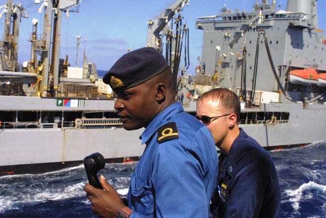 A Kenyan officer acts as conning officer aboard USS Samuel B. Roberts while the ship performs a replenishment at sea with USNS John Lenthall.