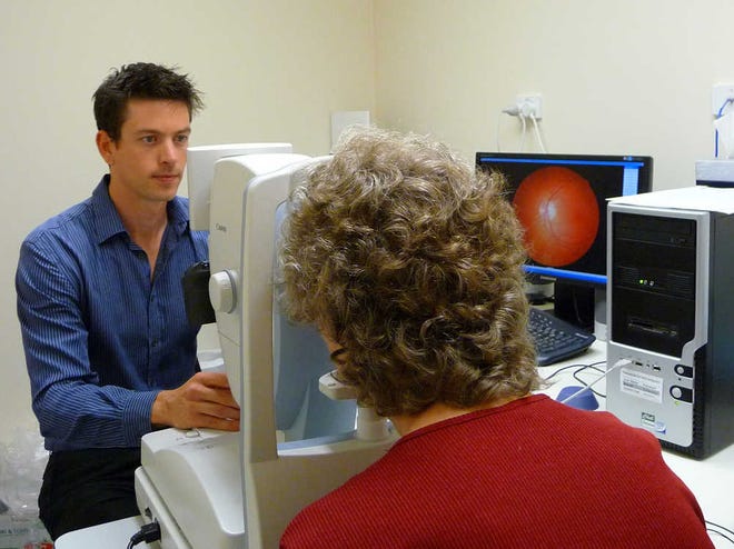 Researcher Shaun Frost of CSIRO Australia, the nation's science agency, photographs a woman's retina as part of a research project into early detection of Alzheimer's disease.