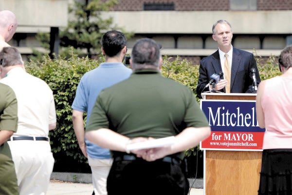 Jon Mitchell, candidate for mayor, outlines his plans for education Tuesday in front of Sgt. William H. Carney Academy elementary school in the West End of New Bedford.