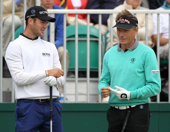 Germany's Martin Kaymer, left, and Germany's Bernhard Langer talk before teeing off the 1st hole during a practice round ahead of the British Open Golf Championship at Royal St George's golf course in Sandwich, England, Tuesday, July 12, 2011. (AP Photo/Tim Hales)