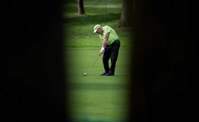 Framed by trees, John Daly hits his second shot on the first hole during Friday's first round of the PGA Canadian Open at the Shaughnessy Golf and Country Club in Vancouver, British Columbia.