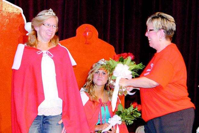 Candy Cox presented flowers to Queen Deb Wielgos with Princess Brittany Ratkowski in the background.