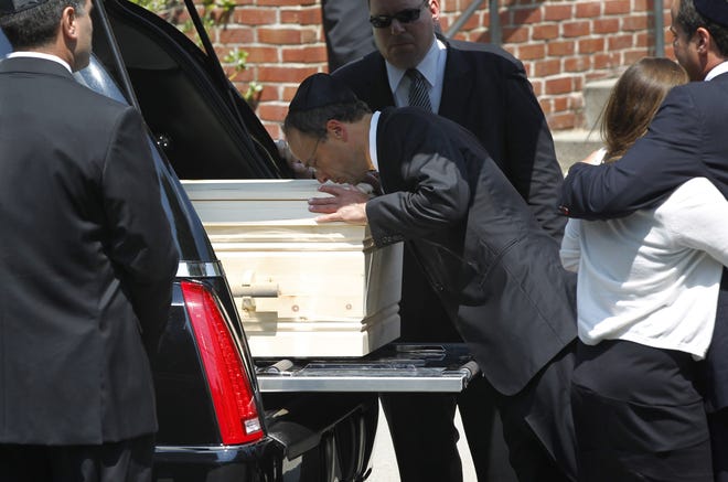 Jonathan Kraft, center, son of Robert Kraft, kisses the casket of his mother Myra Kraft following funeral services at Temple Emmanuel in Newton, Mass., Friday, July 22, 2011. Myra Kraft managed the Robert and Myra Kraft Family Foundation and was president of the New England Patriots Charitable Foundation, which contributed millions of dollars to charities. Robert Kraft is owner of the New England Patriots football team. (AP Photo/Steven Senne)