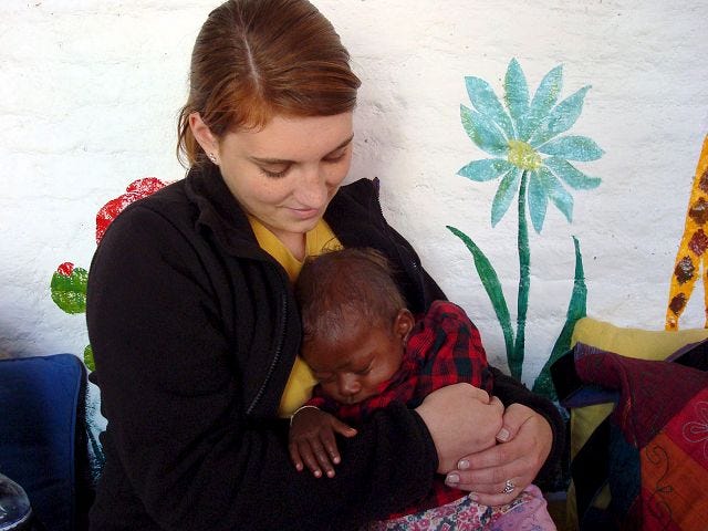 Alison Rhodes comforts a child at an orphanage in Ghana.