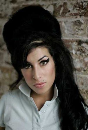 In this Feb. 16, 2007 file photo, British singer Amy Winehouse poses for photographs at a studio in north London. Winehouse, the beehived soul-jazz diva whose self-destructive habits overshadowed a distinctive musical talent, was found dead Saturday, July 23, 2011, in her London home, police said. She was 27. (AP Photo/Matt Dunham, File)
