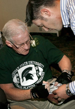 2011 inductee Dick Proebstle autographs a football for Bill Craig on Friday night at Skyland Pines.