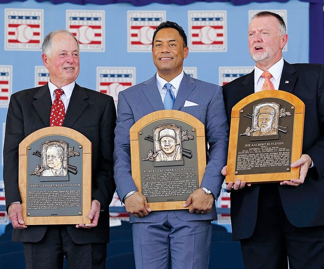 AP Photo/Mike Groll 
Pat Gillick, left, Roberto Alomar, center, and Bert Blyleven hold their plaques after their induction into the Baseball Hall of Fame in Cooperstown, N.Y., on Sunday.