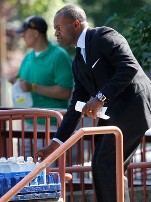 DeMaurice Smith, Executive Director of the National Football League Players' Association, reaches for a bottle of water as he enters Temple Emmanuel in Newton, Mass on Friday.