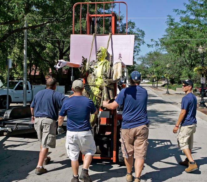 Rockford Park District support maintenance workers remove the vandalized Joe Marino statue from the stone base to have it cleaned Monday, July 25, 2011, at Water and East State streets in Rockford.