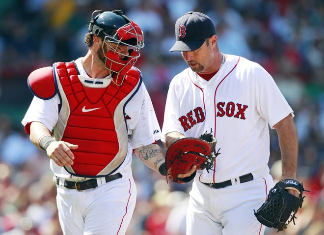 The Red Sox' Tim Wakefield, right, gets the ball from Jarrod Saltalamacchia after striking out the Mariners' Mike Carp in the sixth inning of Sunday's game in Boston. Wakefield joined Roger Clemens as the only pitchers to strike out 2,000 batters with Boston and moved one win away from his 200th victory.