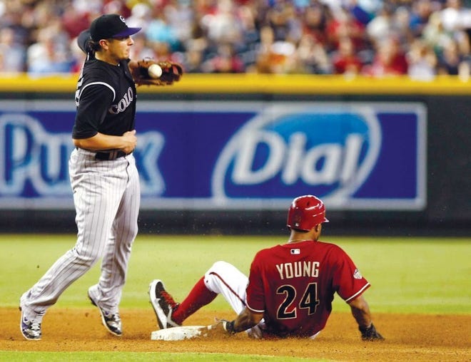 Arizona's Chris Young (right) steals second base as Colorado
shortstop Troy Tulowitzki knocks down the ball in the fifth inning
Sunday in Phoenix.