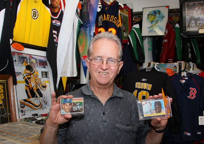 KC's Sports Cards owner Ken Wright holds Ted Williams and Willie Mays cards, at his Quincy shop, Thursday, July 14, 2011.