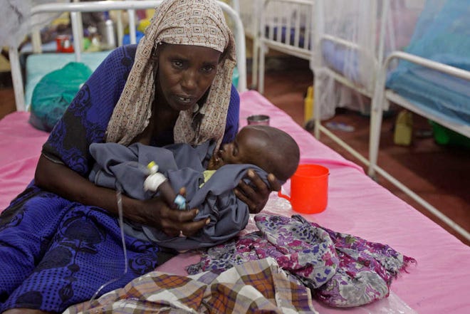 Asiah Dagane holds Mihag Gedi Farah, her seven month old child with a weight of 7 pounds, 8 ounces (3.4 kilograms) at a field hospital of the International Rescue Committee, IRC, in the town of Dadaab, Kenya, Tuesday, July 26, 2011. Mihag Gedi Farah is 7 months old, and weighs as little as a newborn with the weathered skin of an old man. His mother managed to get him to a field hospital in a Kenyan refugee camp after a weeklong odyssey, but the baby's anguished eyes, hollow cheeks and fragile limbs show just how severe Somalia's famine is becoming. (AP Photo/Schalk van Zuydam)