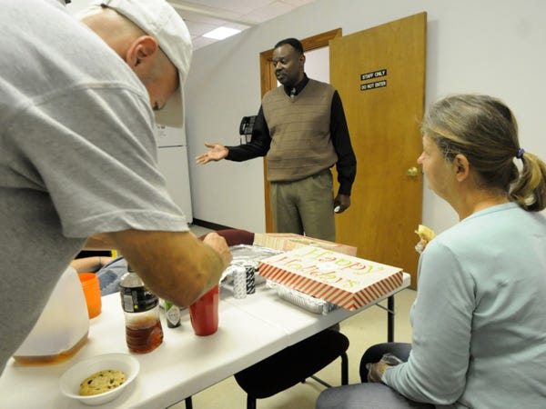 Johnny Young Jr., center, facility director for Le Chris Health System which operates the recently opened Drop In Center, talks with some of the people who have stopped by on Nov. 16, 2010 for a hot meal and access to laundry machines. The center could close on July 29 when Southeastern Center for Mental Health ends its contract to manage the center.