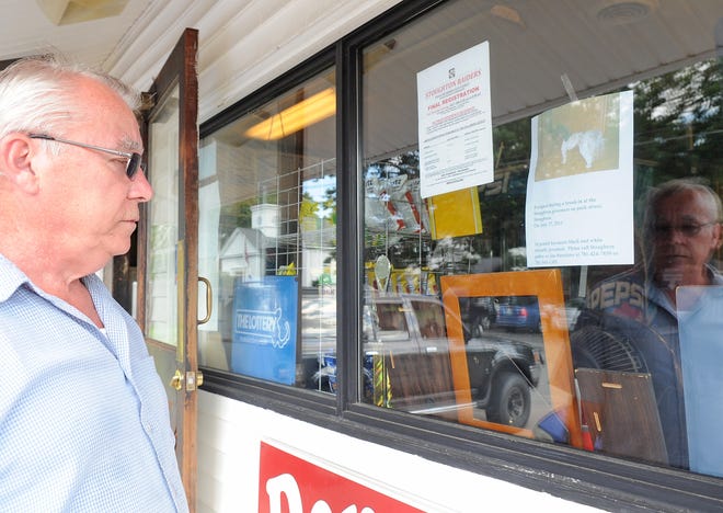 Jim Bannister, 64, looks at a flier he put up in the window of Denneno's Pizza in Stoughton on Thursday, July 28, 2011, for his granddaughter's dog, Happy, who is still missing after Pamela Dowd, 44, allegedly broke the lock on an outdoor gate at Stoughton Groomers during the night and let nine dogs loose.