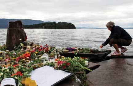 A woman lights a candle in Sundvollen, facing Utoya island,
where gunman Anders Behring Breivik killed at least 68 people, near
Oslo, Norway.