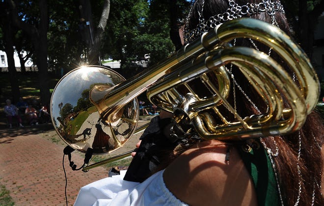Leslie Havens of the trombone trio the Solstice Sackbuts plays the base trombone during the Saturday morning Discovery Series on Union Common in Marlborough.