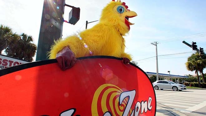 Chris Bonea of West Palm Beach dresses up as a chicken to attract attention for the Wing Zone at the intersection of Military Trail and Community Drive.