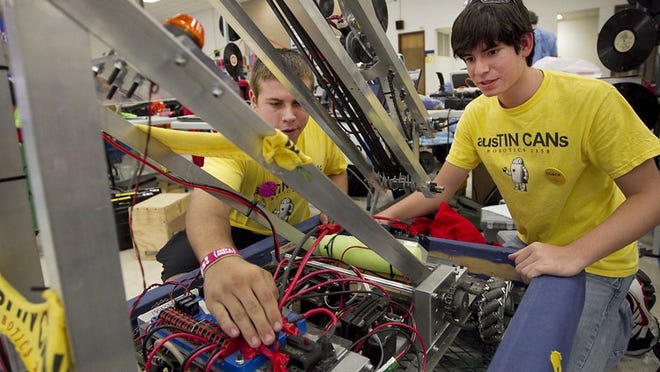 Devin Maynard, left, and Isaac Kravitz of Team AusTIN CANs from Anderson High School work on their robot in the staging area before heading into the next round of competition Saturday at the 2011 Texas Robot Roundup. Anderson High School was the host of the tournament.