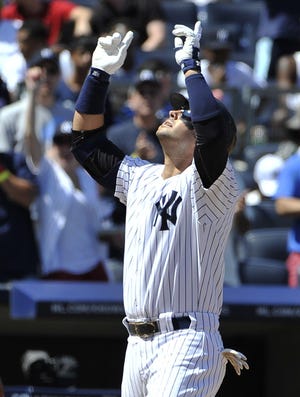 New York Yankees' Nick Swisher points skywards as he crosses home plate after hitting a two-run home run off of Baltimore Orioles starting pitcher Chris Tillman in the fourth inning of the first baseball game of a doubleheader on Saturday, July 30, 2011 at Yankee Stadium in New York.