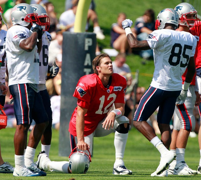 New England Patriots quarterback Tom Brady (12) talks with tight end Aaron Hernandez (85) during an NFL football training camp in Foxborough, Mass., Sunday, July 31, 2011. (AP Photo/Michael Dwyer)