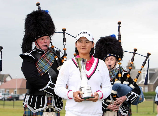 Taiwan's Yani Tseng holds the Women's British Open trophy as bagpipers surround her after she won the tournament on Sunday at Carnoustie Golf Club in Carnoustie, Scotland.