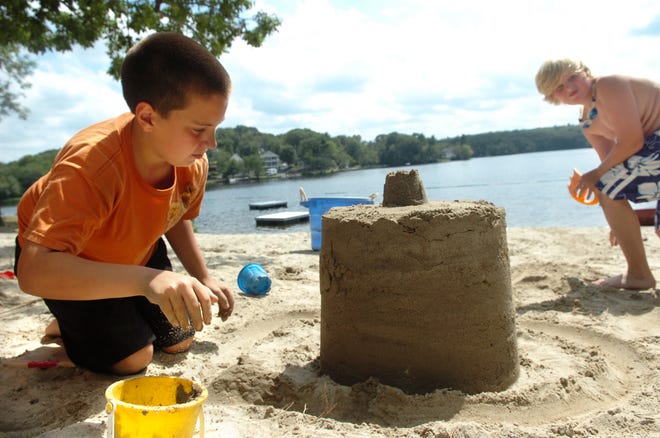 Max Robakiewicz, 11, left, of Upton, puts on the finishing touches to his sand castle with Noah Naworski, 10, of Hopedale at the Kids 'N' Us day camp recently at Milford Town Beach.