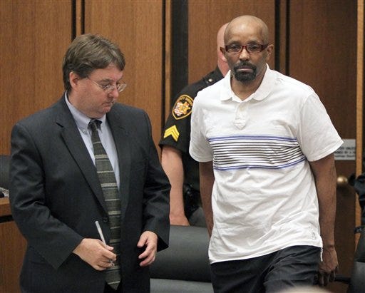 Anthony Sowell, right, the man charged with killing 11 women and dumping their remains around his Cleveland property and home, enters Common Pleas Court as jury selection proceeds in his trial in Cleveland. At left is his attorney John Parker.