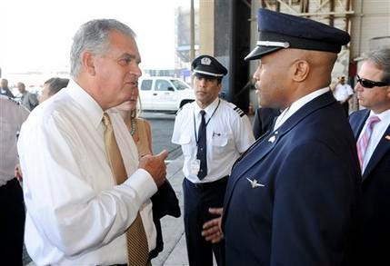 U.S. Transportation Secretary Ray LaHood, left, talks to American Airlines pilot Jesse J. Perkins after a news conference at which LaHood spoke of the interruption of federal funding for airport construction projects and contractors, at LaGuardia Airport in New York, Monday, August 1, 2011. The FAA's operating authority expired at midnight Friday, forcing a partial shutdown of the agency. Dozens of airport construction projects across the country have been put on hold and thousands of federal employees were out of work.