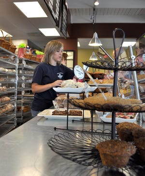 Shelby Ifft, 16, cuts a slice of bread for a customer to taste Thursday at Great Harvest Bread Co.