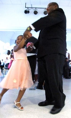 Rickaya Mallory dances with her uncle, Arthur Johnson, during Saturday's "A Night to Remember" father and daughter dance at the Brentwood Lake Community Center in Jacksonville. Like other girls who participated in the inaugural event, the 5-year-old girl attended etiquette, ballroom dancing and character-building classes in order to attend. Girls without fathers were accompanied by other male relatives or by volunteers.