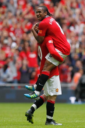 Manchester United's Anderson, right, celebrates with teammate Wayne Rooney after winning against Manchester City at the end of their English FA Community Shield soccer match at Wembley Stadium on London on Sunday.