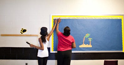 Pat Crawford, with assistance from her niece Sharnae Muhammad, worked on her hallway board last week at Toomer Elementary.