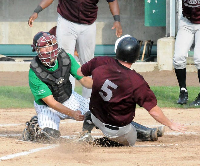 New York’s Jake Rosenbeck slides in to score as he knocked the ball loose from Worcester catcher Anthony Sosnoskie.