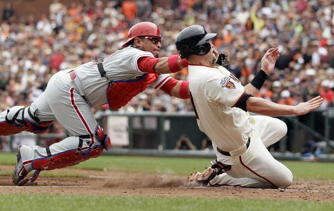 The Giants’ Aubrey Huff is tagged out by Phillies catcher Carlos Ruiz during the fourth inning.