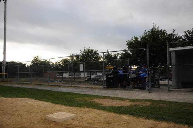 A little league team packs up after practice, vacating the fields as dusk approaches in Raynham behind the Merrill School.