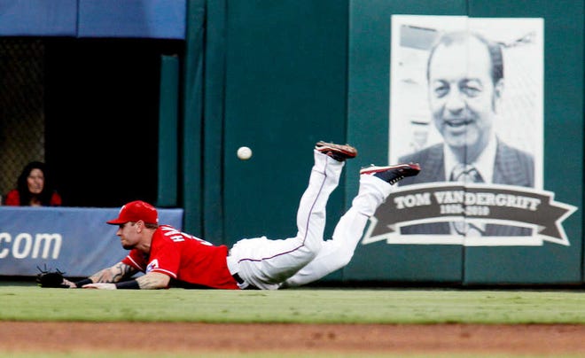 Texas Rangers left fielder Josh Hamilton dives for and misses a hit in the second inning of a baseball game against the Seattle Mariners Tuesday Aug. 9, 2011, at Rangers Ballpark in Arlington, Texas. (AP Photo/Sharon Ellman)