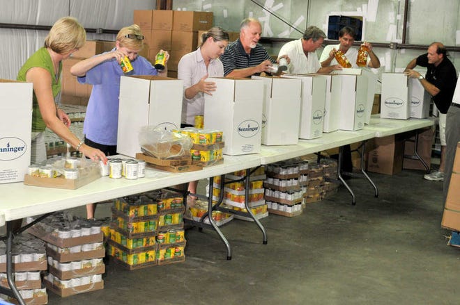 Board members of the Savannah Area Tourism Leadership Council fill more than 200 food boxes with non-perishable food items such as canned vegetables, cereal, juice and pasta at America's Second Harvest of Coastal Georgia warehouse. (Steve Bisson/Savannah Morning News)