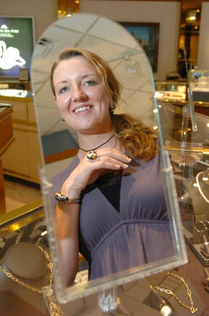 Romm & Co. Jewelers certified bench jeweler Melissa Kelley displays a Belletoile ring, bracelet and necklace as the store prepares for the tax-free weekend in Massachusetts, on Wednesday, Aug. 10, 2011, in Brockton.