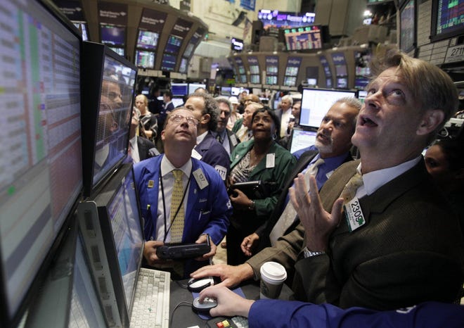 Traders crowd the post of specialist Patrick Murphy, right, on the floor of the New York Stock Exchange Thursday, Aug. 11, 2011.