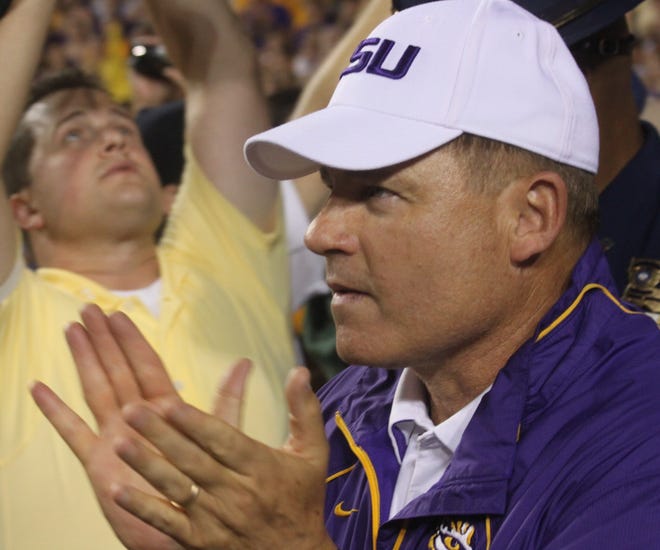Les Miles lead the team onto the field.