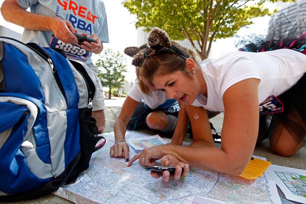 Jamie Elliott, right, of Chillicothe checks a map to figure the best route for her and her teammate Jody Hill of Centerville, hidden behind her, during the Columbus Great Urban Race today.