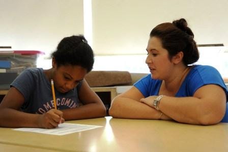 Bridgewater State University instructor Dianna Robbins walks student Jovanna Kiss of Holbrook through a writing exercise.