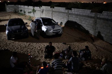 Bedouin smugglers in Rafah, Egypt, smoked in front of cars from Libya that they will transport through tunnels to Gaza.