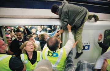 A man is pulled off a commuter train at the Civic Center BART
station in San Francisco on July 11 after climbing on top of it
during a protest against the July 3 shooting by transit police of
Charles Blair Hill.