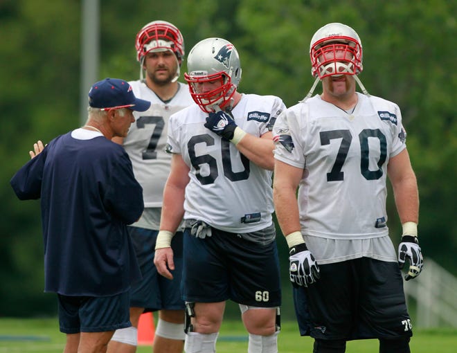 Offensive line coach Dante Scarnecchia, left, instructs offensive tackle Sebastian Vollmer, second from left, guard Rich Ohrnberger (60) and guard Logan Mankins (70) during a practice last week.